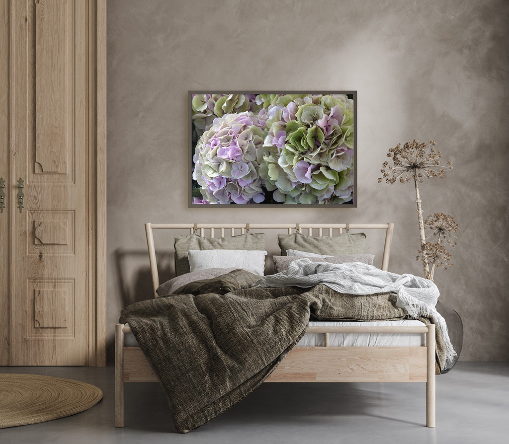Bedroom with a wooden bed, green blanket, and floral artwork on the wall.