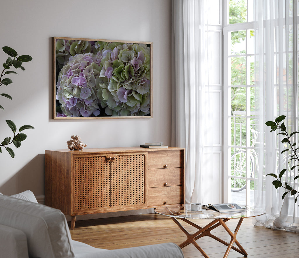Living room with wooden cabinet, glass coffee table, and framed floral artwork.
